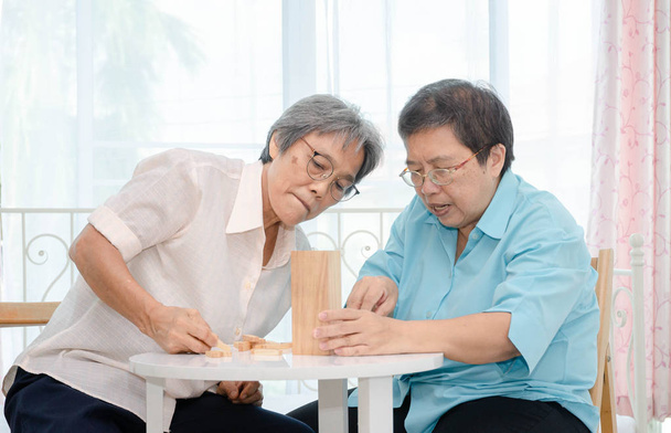 Asiatiche donne anziane che indossano una camicia blu e amico stanno giocando Divertiti al mattino a casa in camera
. - Foto, immagini