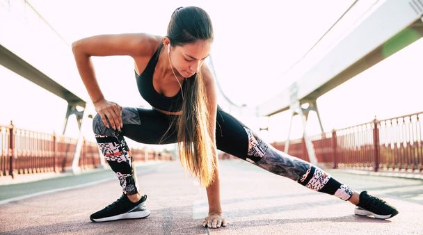 Stile di vita femminile sportivo e sano. Attraente giovane ragazza bruna sta facendo esercizi mattutini prima di correre
 - Foto, immagini
