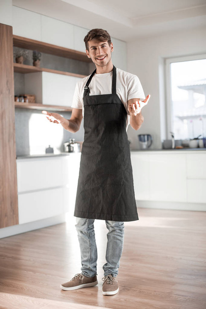 in full growth. attractive young man standing in home kitchen - Valokuva, kuva
