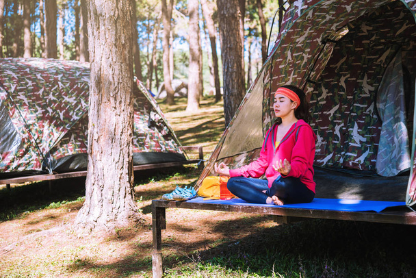 Giovane donna asiatica che fa yoga durante il campeggio nella foresta
 - Foto, immagini
