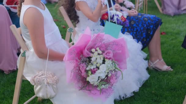 Gäste kleine Mädchen mit Blumensträußen sitzen auf einer Hochzeitszeremonie - Filmmaterial, Video