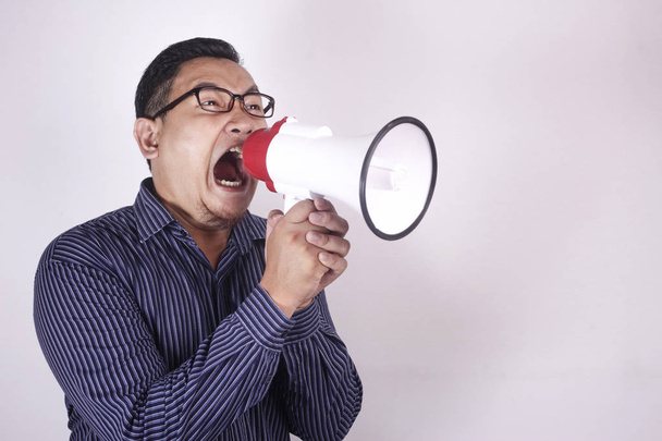 Mladý muž křičící s megafonem, rozzlobený výraz - Fotografie, Obrázek