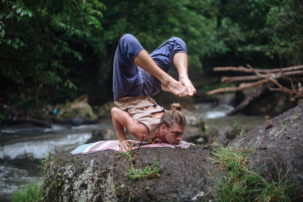 Praktyka jogi i medytacja w przyrodzie. Człowiek praktykujący w pobliżu rzeki - Zdjęcie, obraz