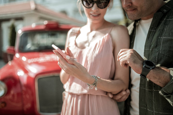 Vrouw toont haar man Foto's op haar Smartphone. - Foto, afbeelding