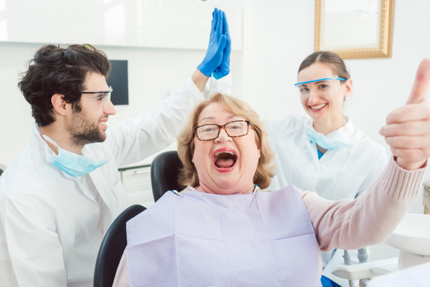 Dentyści i pacjent w chirurgii jest nieco ponad górę podekscytowany - Zdjęcie, obraz