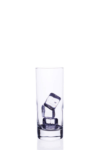 Порожня скляна чашка для коктейльних кубиків льоду на білому тлі
. - Фото, зображення