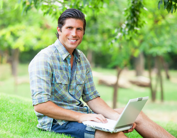 Student with laptop at green grass - Foto, imagen