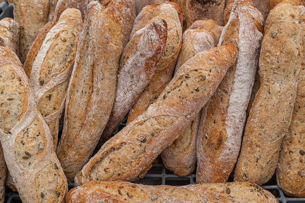 A close up of small freshly baked rustic baguettes for sale at a farmers market - Photo, Image