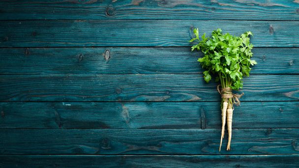 Root parsley on a wooden background. Top view. Free space for your text. - Valokuva, kuva