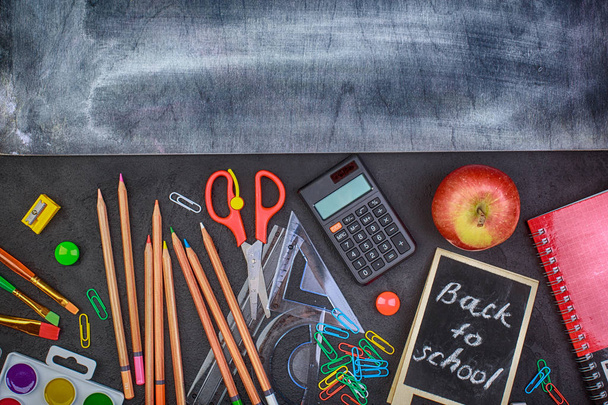Iskolai kellékek fekete fedélzeten háttér színes vissza az iskolába - Fotó, kép