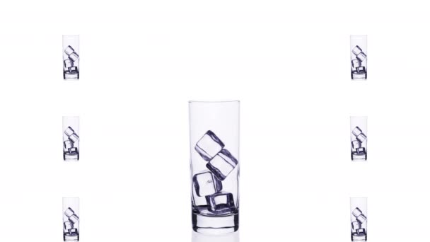 Glas mit blauem Cocktail und Eiswürfeln füllen und entleeren in Stop-Motion über weißem Hintergrund isolieren. - Filmmaterial, Video