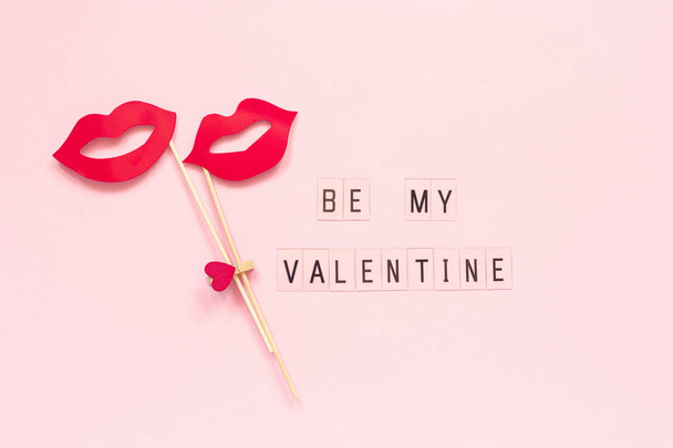Text Be my Valentine and couple paper lips props on stick fastened clothespin heart on pink background. Concept lesbian love Creative Valentine's Day, Valentine card Top view - Фото, изображение