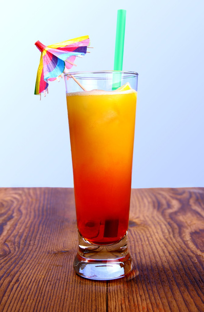 Red, yellow cocktail and lemon, straw with umbrella deco - Фото, зображення