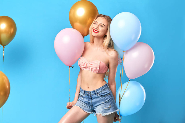 Pretty cute blonde girl with balloons expresses positive emotion - Fotó, kép