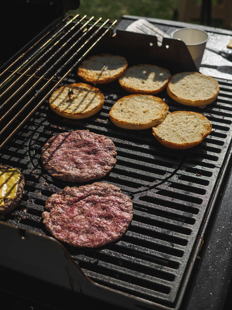 Cooking burgers with beef meat in grill bbq street festival - 写真・画像