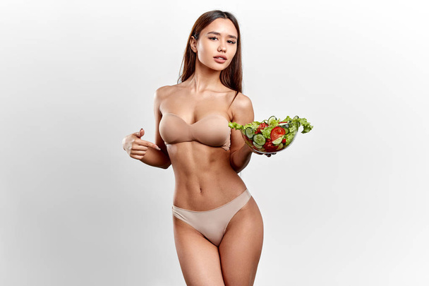 awesome nude sexy girl holding salad and pointing to it - Photo, Image