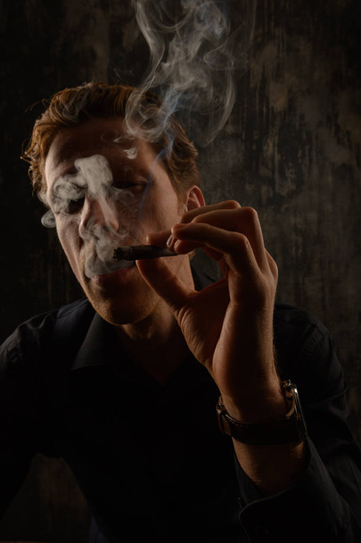 Brutal Mystery man with cigar and smoke isolated on black background - Foto, afbeelding
