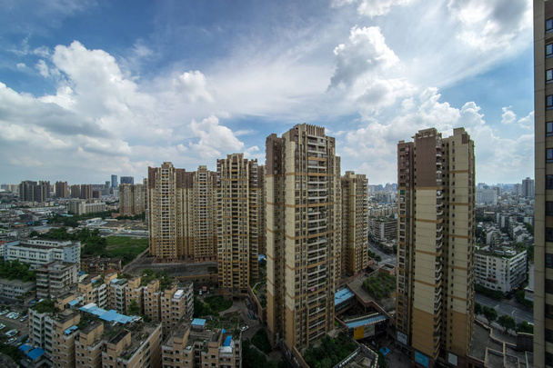 αστικό τοπίο της σύγχρονης μεγάλης πόλης με ψηλά κτήρια, μπλε ουρανό και λευκά σύννεφα. Pujun νέα πόλη, Φοσάν, περιοχή chancheng, επαρχία Γκουανγκόνγκ, Κίνα - Φωτογραφία, εικόνα