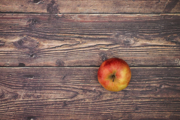 One red and fresh apple on the wooden table  - Foto, afbeelding