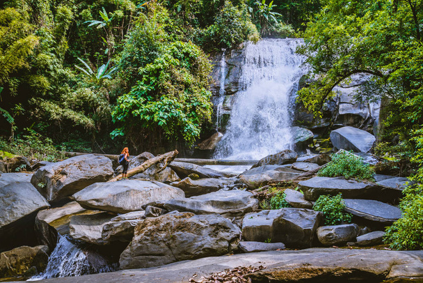 Kobiety podróżują. Kobieta Azja podróżuje przyroda Lasy, góry, wodospady. Wodospad krzemowy w Chiangmai, Tajlandia. - Zdjęcie, obraz