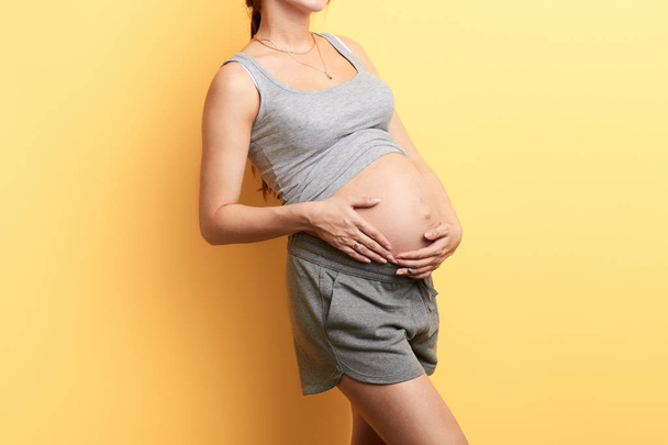 woman adores her future baby, touching her belly - Фото, зображення