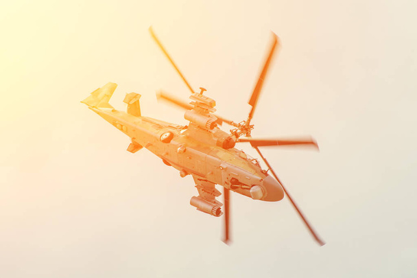 Militaire gevechtshelikopter vliegt snel draaien met een hoge invalshoek in de lucht. - Foto, afbeelding