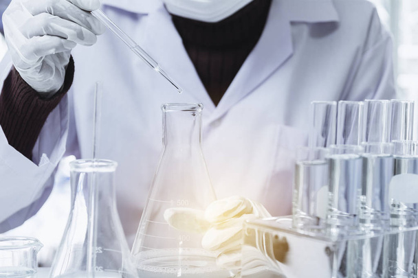 Researcher with glass laboratory chemical test tubes with liquid - Zdjęcie, obraz