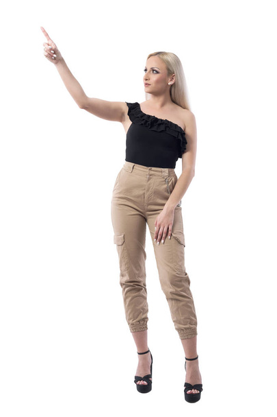 Elegant stylish blonde woman in fashion style clothes pointing finger up selecting. Full body isolated on white background.  - Фото, изображение