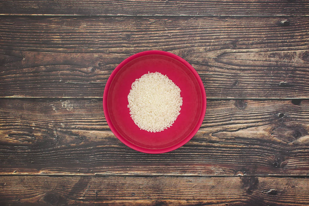 White rice in pink dish on the wooden table  - Foto, Imagen