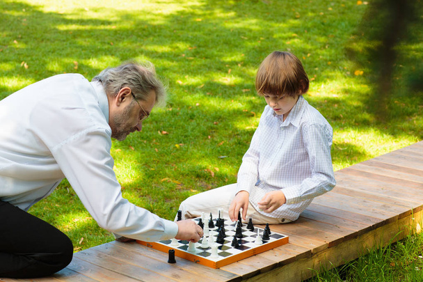 Grandfather, father and kids playing chess. - Photo, Image
