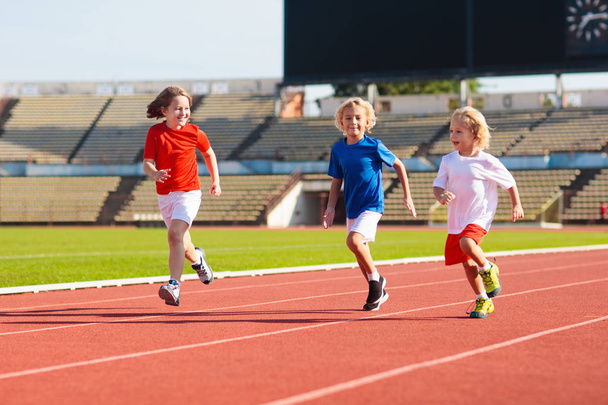 Child running in stadium. Kids run. Healthy sport. - Foto, Imagen