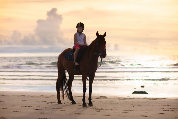 Kids riding horse on beach. Children ride horses. - Photo, Image