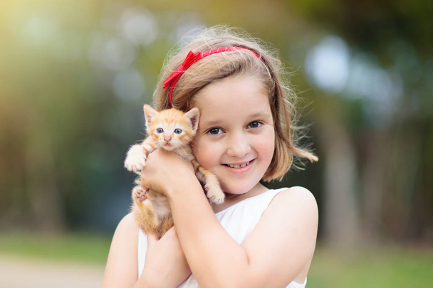 Niña sosteniendo gato bebé. Niños y mascotas
 - Foto, imagen