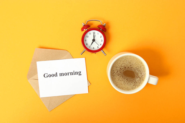 wekker en koffie op een gekleurde achtergrond bovenaanzicht. - Foto, afbeelding