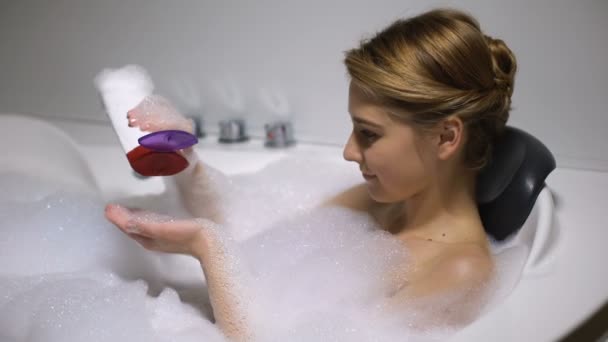 Woman in bath with foam bubbles applying body wash, beauty procedure, freshness - 映像、動画