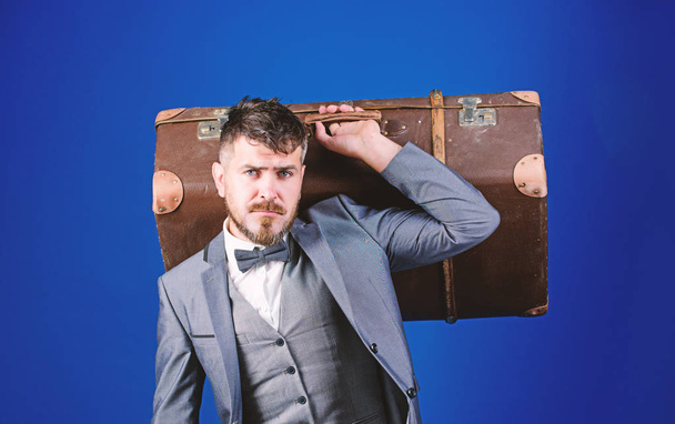 stylish esthete with vintage bag. heavy bag. mature traveller. business trip with retro suitcase. bearded man in formal suit. businessman in bow tie. Perfect style. Enjoying travel - Фото, изображение