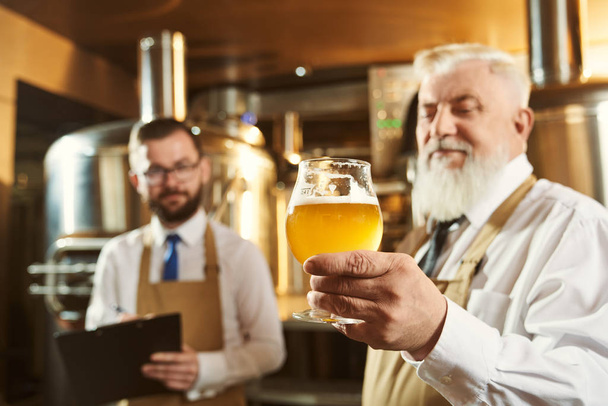 Experts examining beer at factory. - Foto, Bild