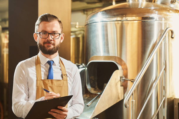 Expert of brewery holding folder, posing, looking at camera. - Zdjęcie, obraz