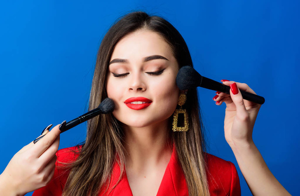 Pretty woman applying makeup brush. Perfect skin tone. Stunning beauty. Makeup supplies shop. Makeup courses. Gorgeous lady make up red lips. Skin care. Cosmetics concept. Beauty salon facial care - Фото, зображення