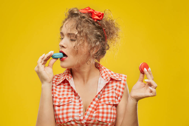 Sexy girl biting colorful macaron, enjoying. - Photo, Image