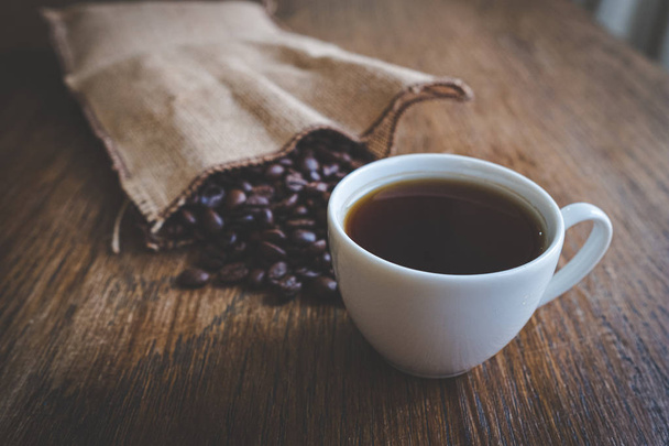 Espresso und Kaffeebohnen auf einem Tisch - Foto, Bild