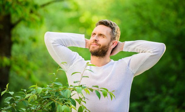 Nature peaceful environment. Natural beauty remedies. Keep it healthy way. Nature relax spa resort. Feel power of nature. Man handsome bearded guy morning stretching nature background. Meet new day - Photo, Image