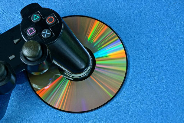 nero joystick di gioco è su un cd su un tavolo blu
 - Foto, immagini