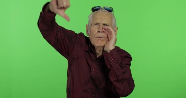 Senior man something giving thumb down. Handsome old man showing displeasure - Footage, Video