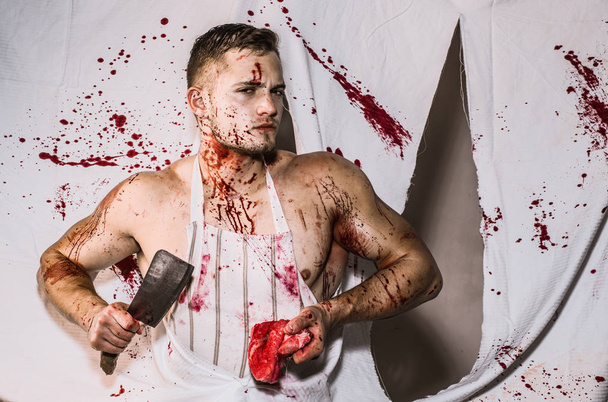 Steak or beefsteak - bloody meat. Splashing blood. A young man is holding a knife in hands and slices of meat. False imagination of masculinity. - Photo, Image