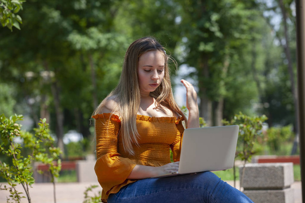 Young woman with laptop on green grass at park - Foto, Imagem
