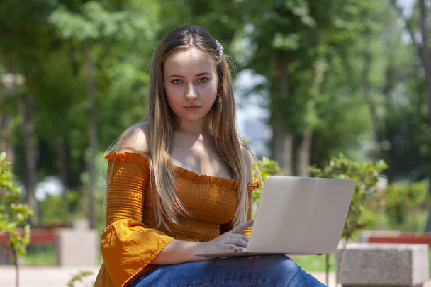 Young woman with laptop on green grass at park - Fotografie, Obrázek