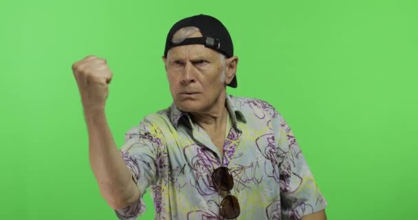 Senior hombre turístico peleas a alguien amenazadoramente se mueve con sus manos puño
 - Metraje, vídeo