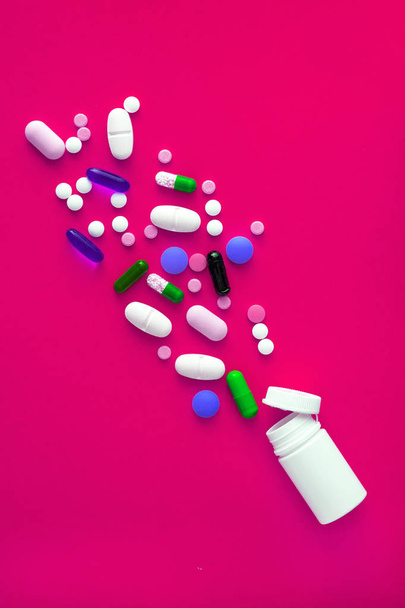 A variety of medicinal pills and pills poured out of the vial on a yellow background. Flat lay. Copy space. Trend. The concept of a healthy, bright, modern medicine and pharmacology - Photo, Image