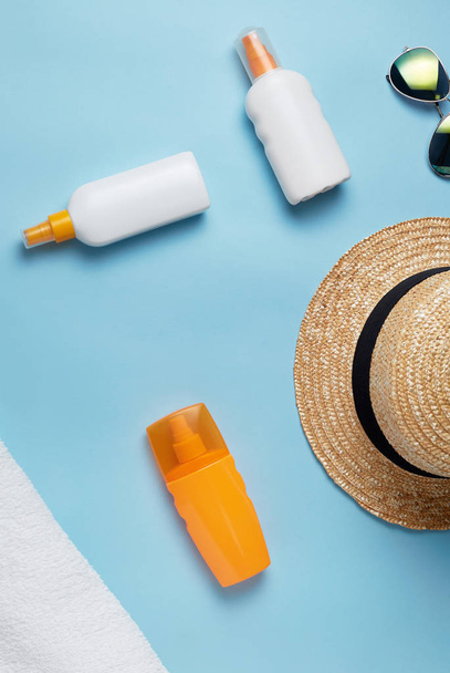 beach bag with beach accessories on a colored background top view. Sunscreen, towel, glasses, hat. - Foto, Imagem